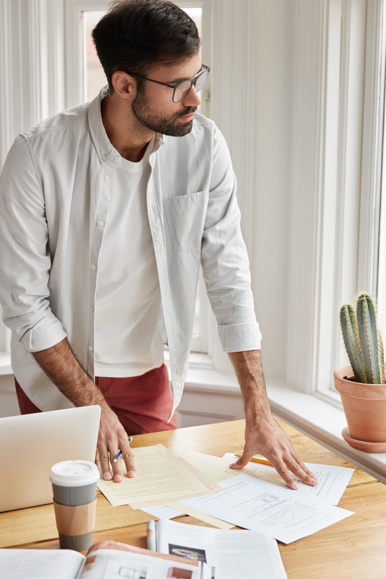 vertical-shot-of-male-coworker-cant-make-right-accountings-in-papers-looks-at-documents-planner-st.jpg